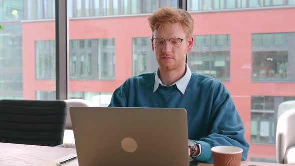 Confident Young Businessman Work Online at Work Place Type on Laptop in Office