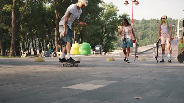 Group of Young Skaters Doing Tricks on the Boards in the City Park