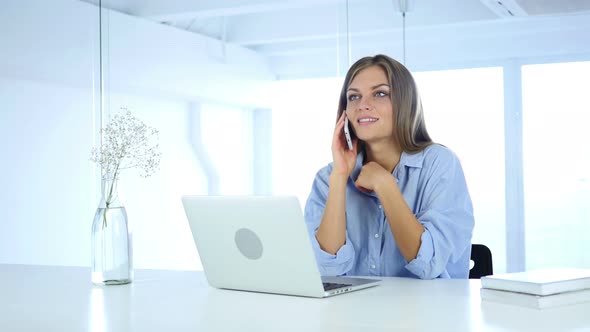 Woman Talking on Phone at Work with Customer