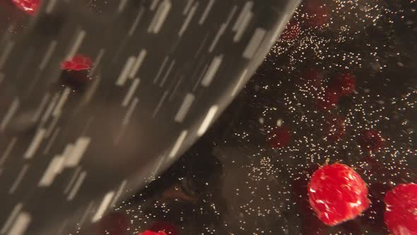 CloseUp Of Raspberries In Water Against Black Background