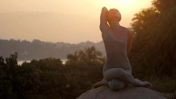 Yoga Teacher Does Gomukhasana on Rocks at Trees Slow Motion