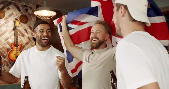 Men with the Flag of the National Country of Great Britain Watching Sport Game