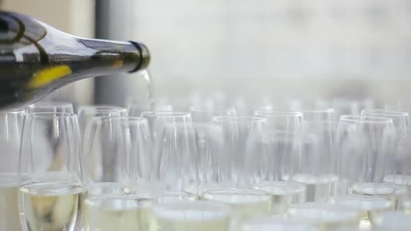 Man Fills Glass of Champagne for Guests of the Wedding Party of the Bride and Groom in the Banquet