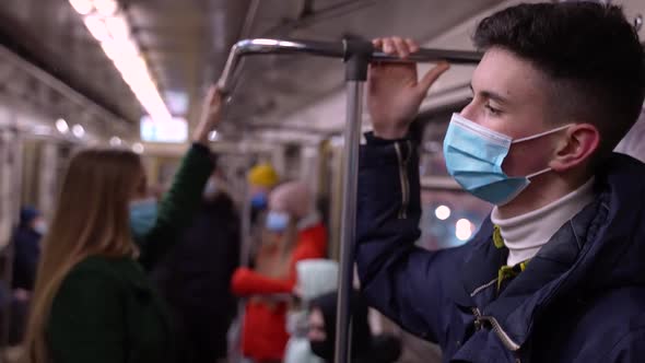 Tall Young Man in Face Mask Riding in Subway Train