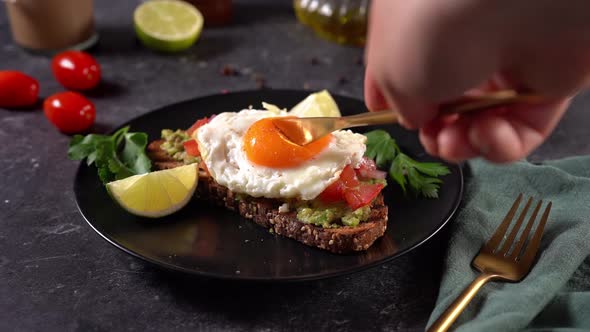 Cutting Yolk on Avocado Toast with a Knife