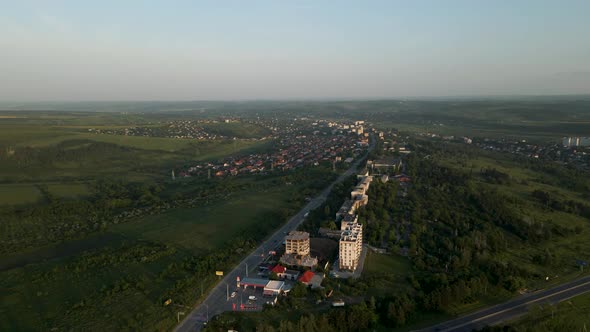 the Drone's Flight Over the Small Town in the Sunlight at Sunset