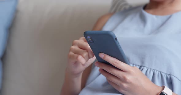 Woman use of cellphone and sit on sofa at home