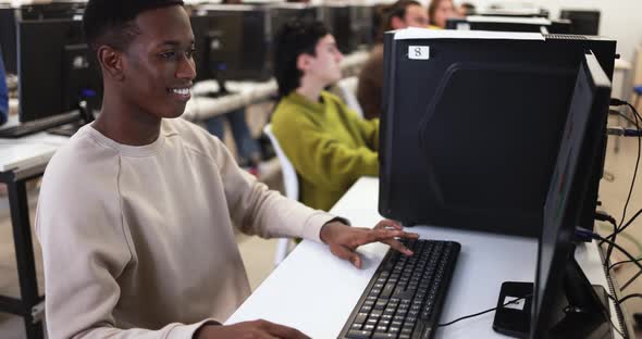 Young multiracial people using computers inside school classroom at university