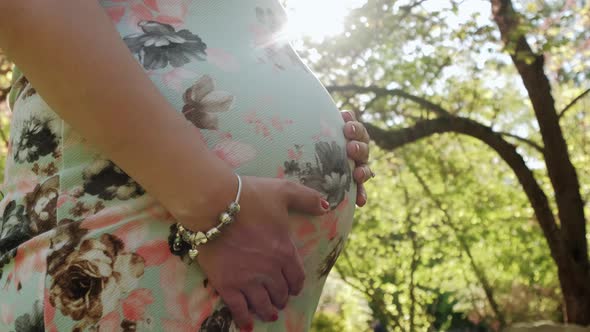 Close Up of Happy Pregnant Woman Caressing Belly an the Forest