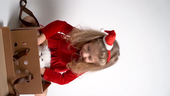 Little Blonde Girl in Red Dress Unpacking a Christmas Gift Girl a Gift for Christmas Vertical