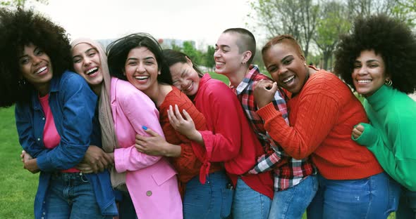 Young multiracial women having fun laughing together at city park - Diversity concept