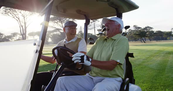 Two golfers laughing together in their golf buggy