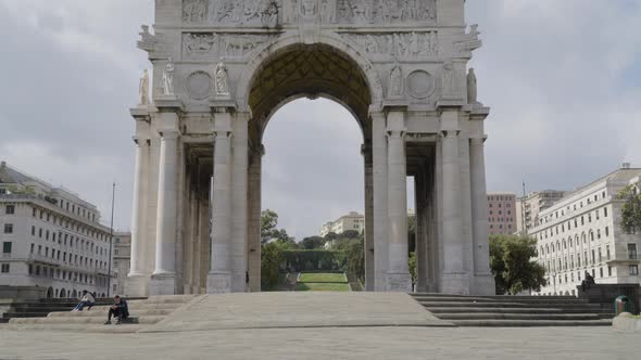 Arco Della Vittoria in city of Genoa, tilting up view with cloudy sky