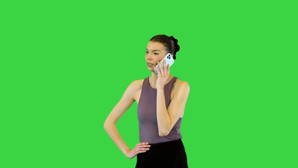 Young Ballerina Talks on Mobile Phone Making a Little Warmup on a Green Screen Chroma Key