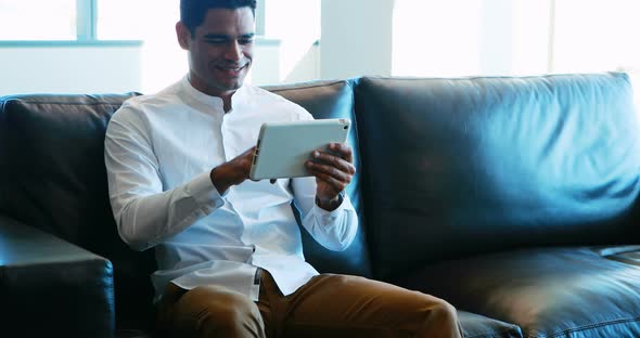 Male executive using digital tablet on sofa