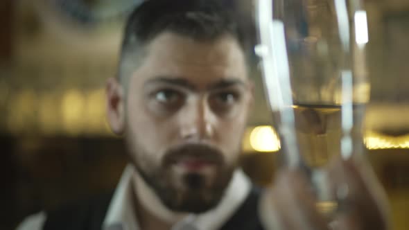 Portrait of a Bartender Looking at a Beer Glass