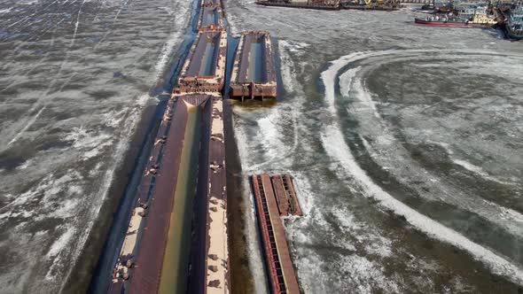 Old Ship Barge on a Frozen River Covered with Ice Aerial Filming at Sunset