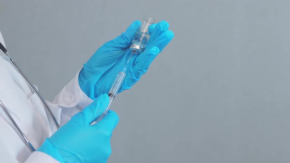 Hands Blue Gloves Taking Liquid Vaccine Medicine From Glass Ampoule with Syringe