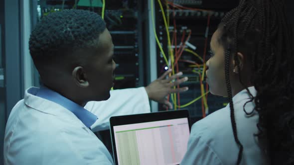 African american computer technicians using tablet working in business server room