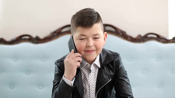 Little Schoolboy Talking on a Smartphone