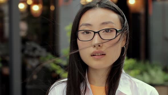 Portrait of Beautiful Trendy Asian Woman in Eyeglasses Smiling at Camera Looking