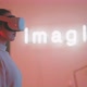 Profile view of a young woman wearing vr goggles with imagine sign in the background - VideoHive Item for Sale
