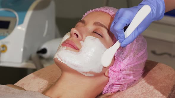 Happy Woman Smiling During Facial Mask Application at Beauty Salon