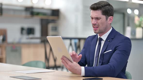 Disappointed Businessman Reacting To Loss on Tablet 