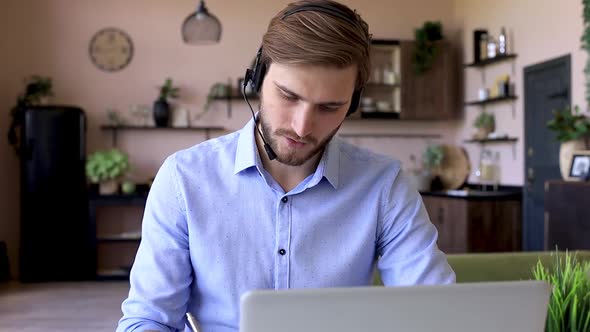 Confident man wearing headset speaking and watching business webinar training, listening to lecture.