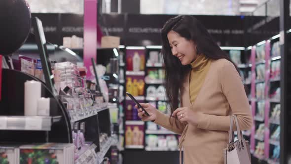 Woman Taking Shots On Smartphone In Make-Up Shop