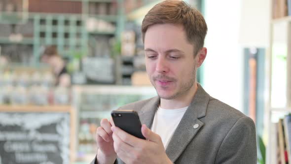 Portrait of Young Man Celebrating on Smartphone