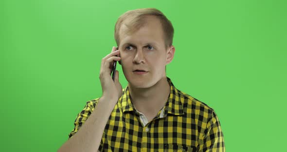 Caucasian Young Man in Yellow Shirt Using Mobile Phone for Call