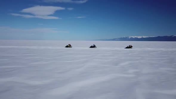 Aerial View Snowmobiles Ride on the Frozen Lake Baikal in Winter