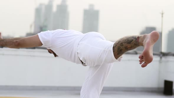 Man Accomplishing Intermediate Balancing Yoga Pose By Standing With One Leg