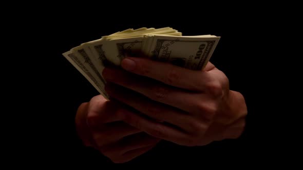 Male hands holding many banknotes isolated on black background