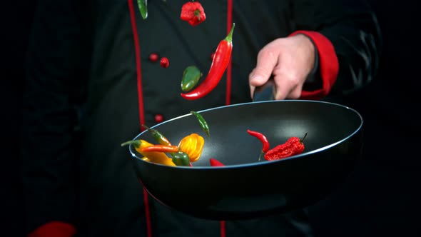 Super Slow Motion Shot of Chef Holding Frying Pan and Falling Chilli Peppers at 1000Fps