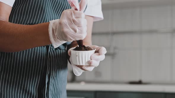 Woman Chef Making a Cake  Putting Cherry Filling in the Pastry Bag and Applying It Into the Cupcakes