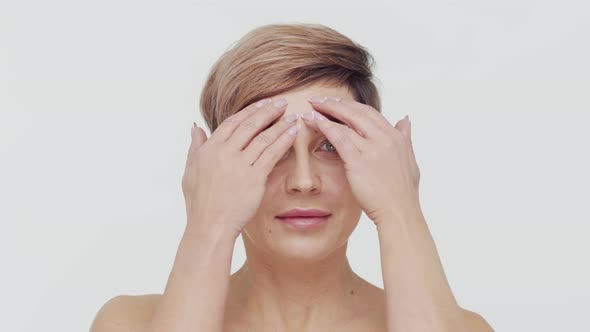 Close-up of middle aged mature woman over white background.