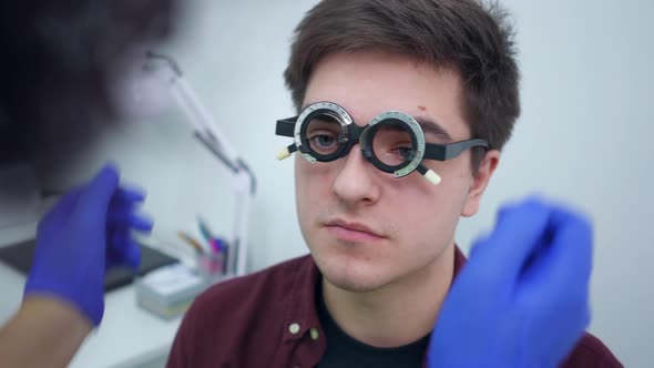 Closeup Portrait of Young Caucasian Man with Bad Eyesight Sitting in Hospital As Unrecognizable