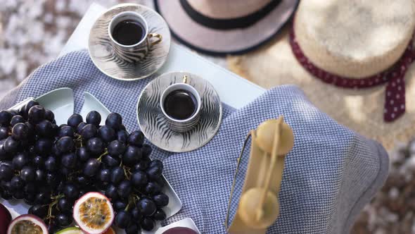 Top View Table with Delicious Black Coffee and Tasty Healthful Vitamin Fruits on Sunny Day Outdoors