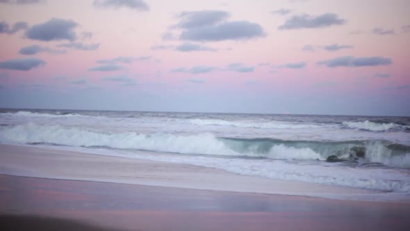 Waves crashing on beach at sunset