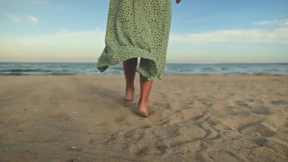 Attractive Slim Legs of a Woman in Slow Motion Walking Barefoot Along the Beach in the Early Morning
