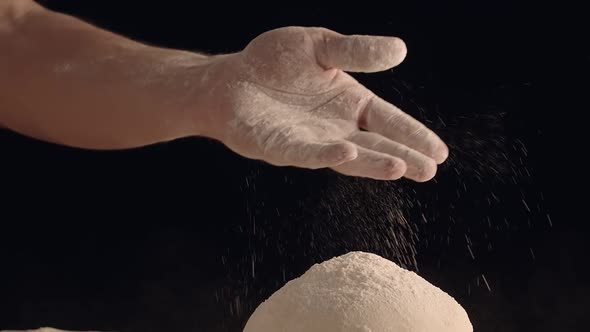 Male Hands Sprinkle a Piece of Baking Dough with Flour