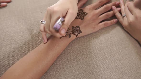 Close Up Shot of a Woman's Hands, Who Is Applied Moisturizing Oil on Mehendi