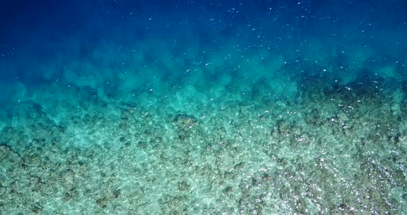 Natural overhead travel shot of a white paradise beach and blue sea background in vibrant 4K