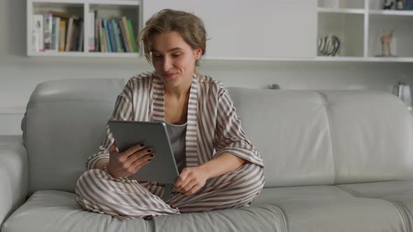 Housewife Enjoy Online Chatting Holding Tablet Computer in Hands Living Room