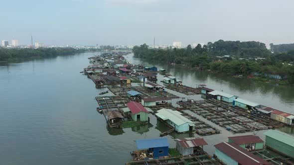 slow tracking drone shot over floating fish farming community in Bien Hoa on the Dong Nai river, Vie