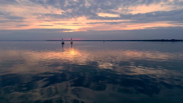 Aerial Drone Footage of Peaceful Scene with Yachts Cruising at Calm Water at Dusk