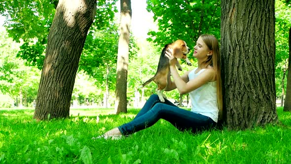 Happy Woman with a Dog Beagle Playing on Nature. Slow Motion