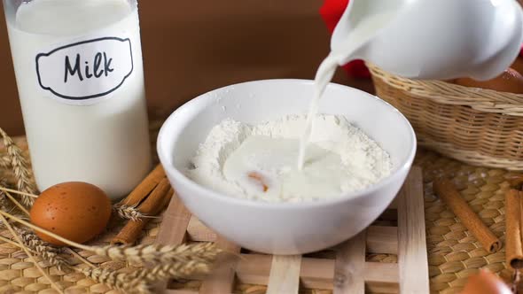 Closeup of Pouring Milk Into a Flour